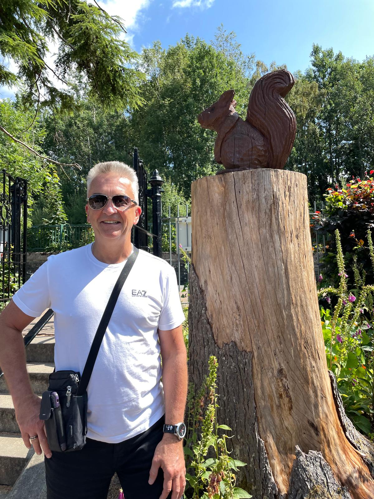 Martin Davies, Sales Adviser, beside a carved wooden squirrel